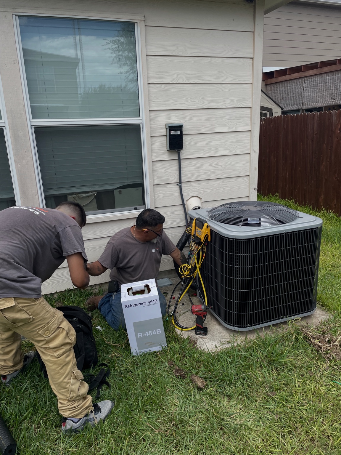 Technicians installing new condenser